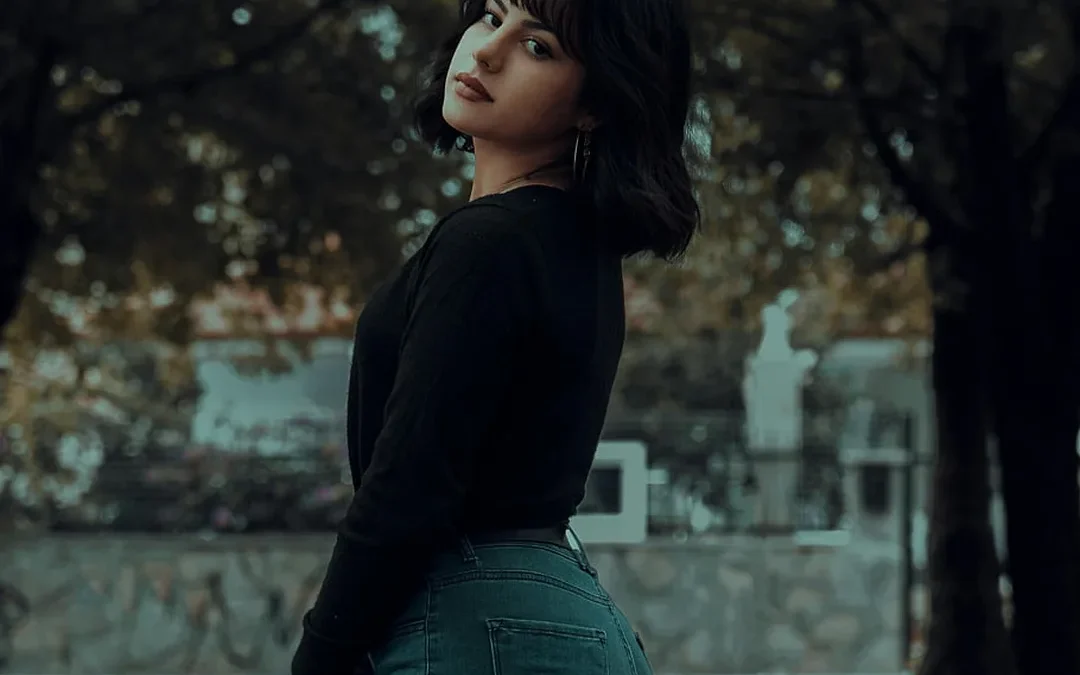 petite fall outfits — woman in black sweater and jeans in autumn park